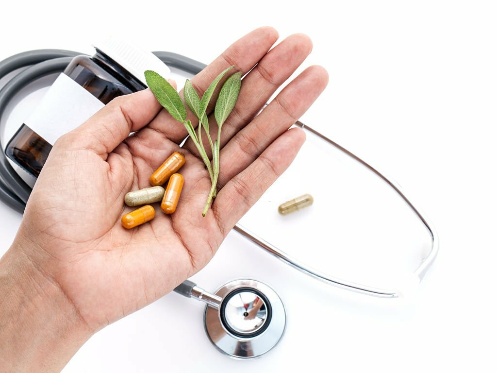 Alternative health care fresh herbal and capsule in doctor 's hand