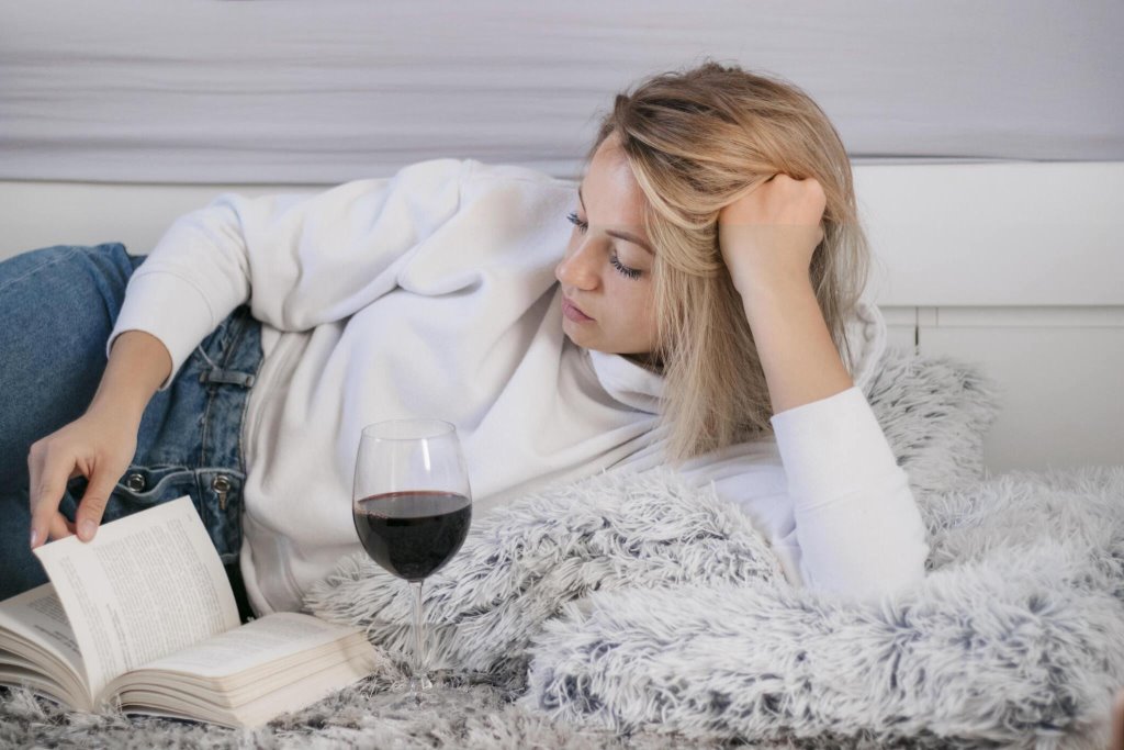 Woman reading book with wine