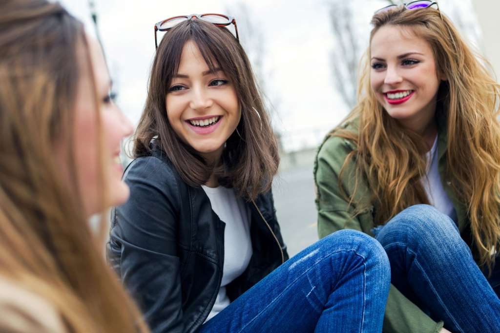 young women talking and laughing in the street.