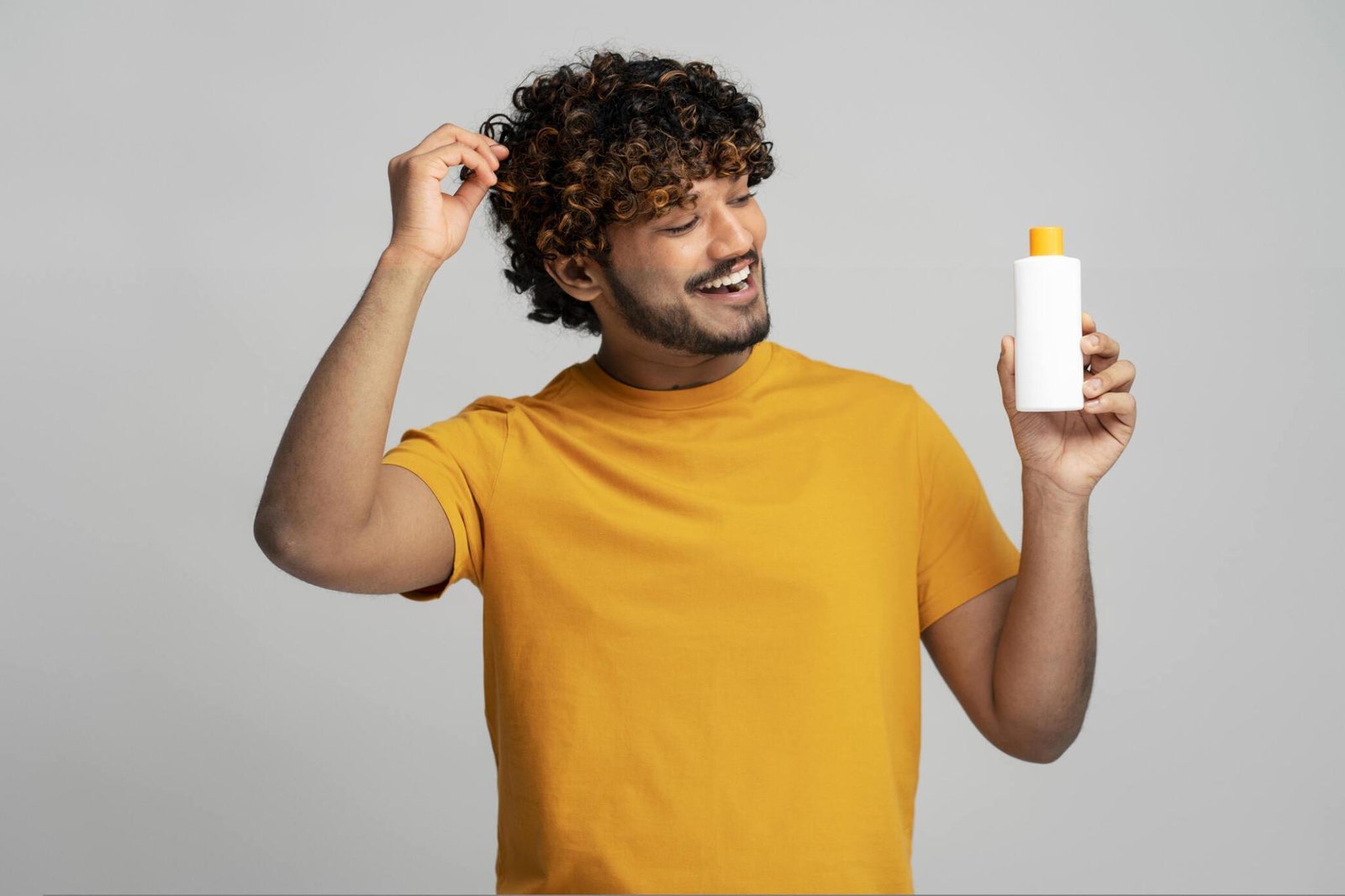 man holding bottle with hair shampoo
